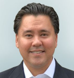 Headshot of Matthew Panuwat Chief Business Officer on light sage background